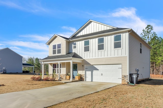 view of front of house featuring a porch, an attached garage, concrete driveway, stone siding, and board and batten siding