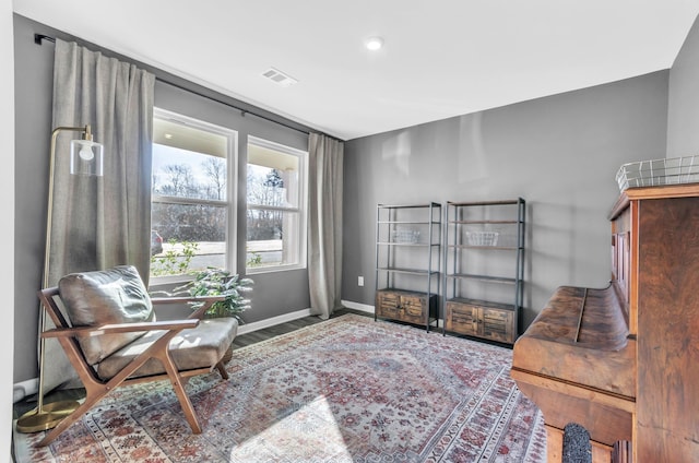 sitting room featuring visible vents, baseboards, and wood finished floors