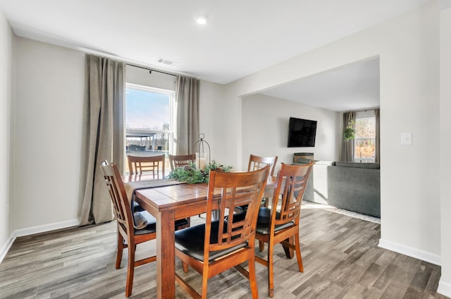 dining area featuring a healthy amount of sunlight, visible vents, and wood finished floors