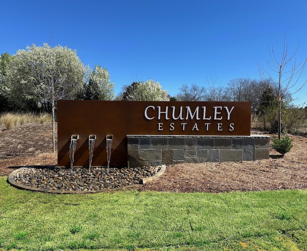 community / neighborhood sign with a yard