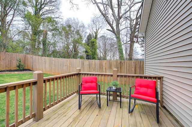 wooden deck with a fenced backyard and a lawn