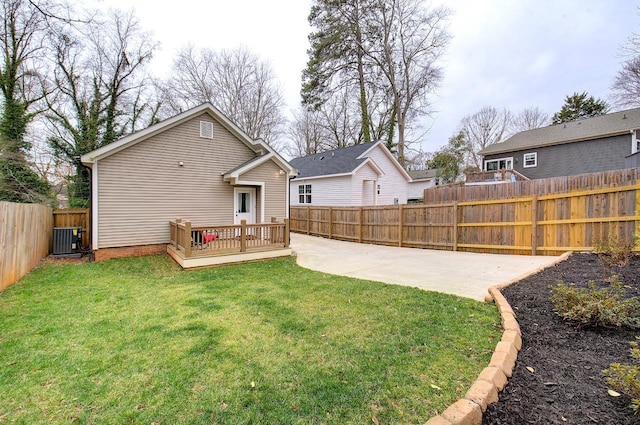 rear view of house with central AC unit, a fenced backyard, driveway, a yard, and a wooden deck