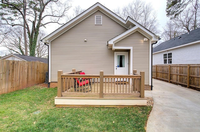 rear view of property featuring a yard, a fenced backyard, and a wooden deck