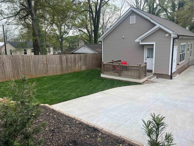 rear view of house with a patio area, a lawn, a deck, and fence