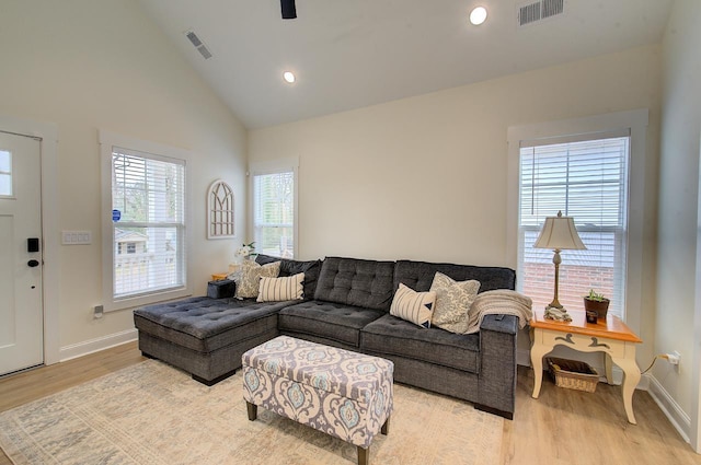 living room with light wood-style floors, baseboards, and visible vents