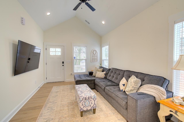 living area with ceiling fan, high vaulted ceiling, visible vents, baseboards, and light wood finished floors