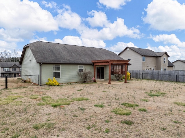 back of property featuring roof with shingles, a patio area, and a fenced backyard