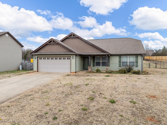 view of front of house with a garage, driveway, and fence