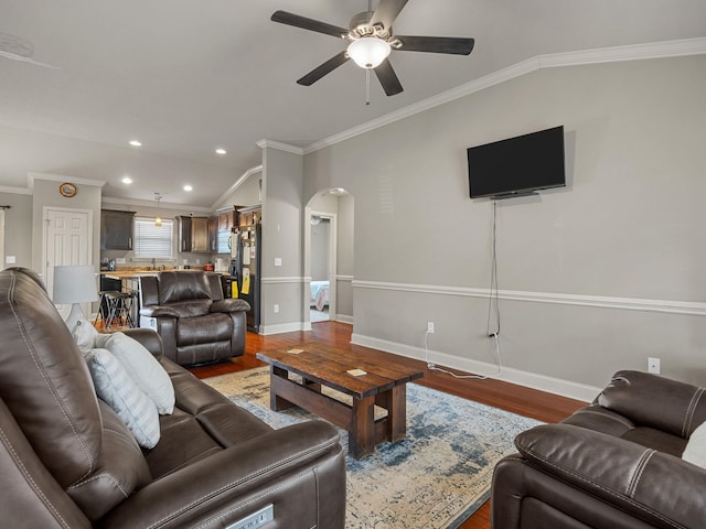 living room with baseboards, arched walkways, wood finished floors, and ornamental molding