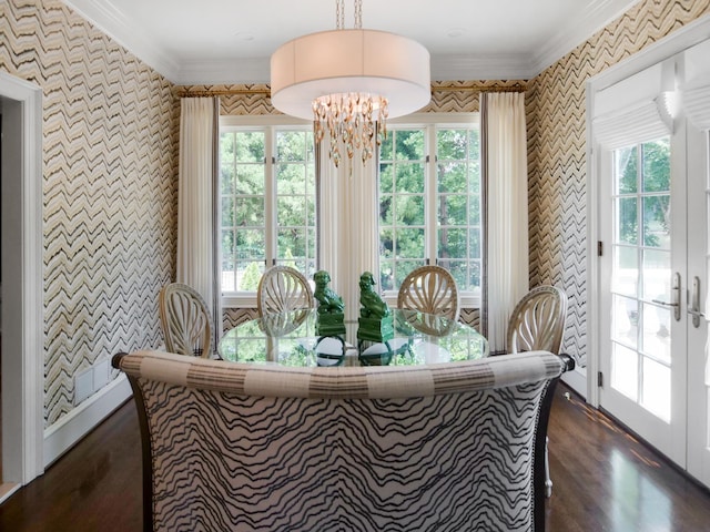 dining space featuring ornamental molding, an inviting chandelier, a wealth of natural light, and wallpapered walls