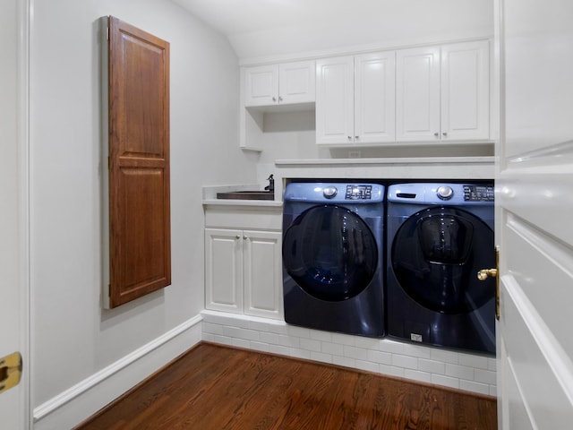 laundry area with dark wood-style floors, cabinet space, separate washer and dryer, and a sink