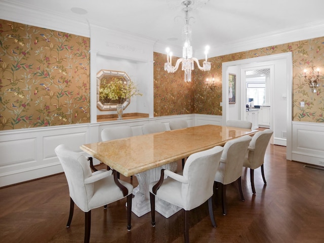 dining area featuring a chandelier, wainscoting, ornamental molding, and wallpapered walls