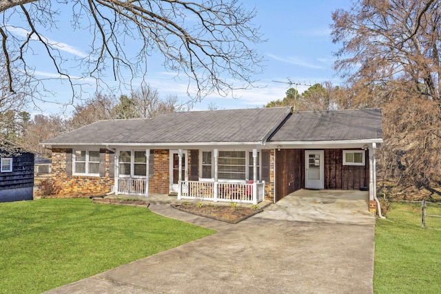 ranch-style home with driveway, metal roof, a front yard, a porch, and brick siding