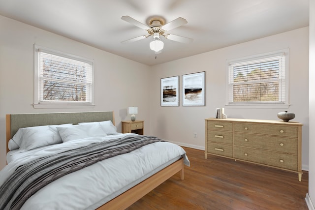 bedroom with dark wood-style floors, multiple windows, baseboards, and a ceiling fan