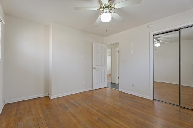 unfurnished bedroom featuring wood-type flooring, baseboards, and ceiling fan