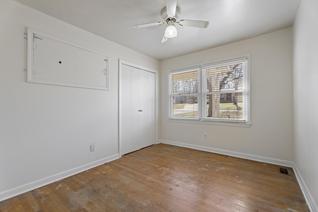 spare room featuring hardwood / wood-style flooring, baseboards, visible vents, and ceiling fan