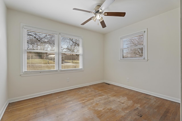 empty room with light wood-style floors, plenty of natural light, and baseboards