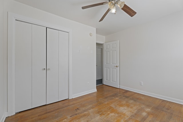 unfurnished bedroom featuring light wood finished floors, ceiling fan, baseboards, and a closet