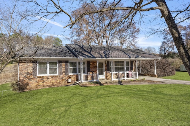 single story home with driveway, brick siding, covered porch, a carport, and a front yard