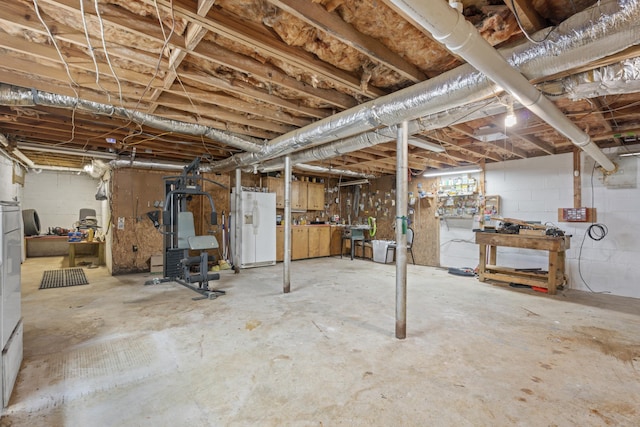 unfinished basement with white refrigerator with ice dispenser