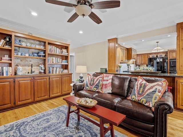 living room featuring light wood finished floors, ornamental molding, a ceiling fan, and recessed lighting