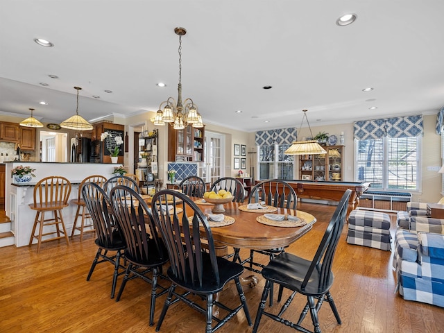 dining space featuring an inviting chandelier, light wood-style flooring, ornamental molding, and recessed lighting