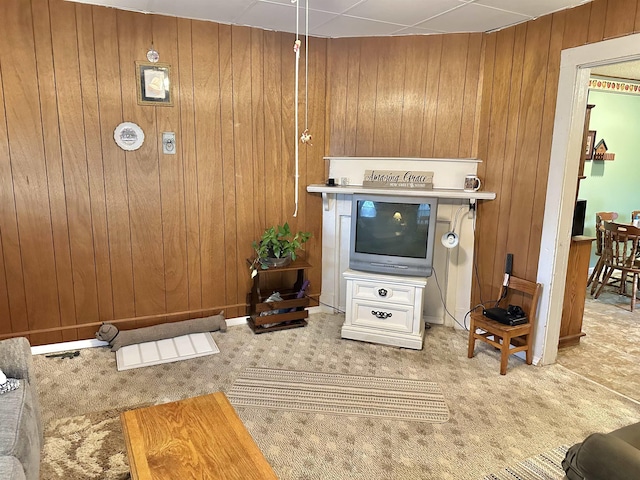 living area with wood walls and light colored carpet