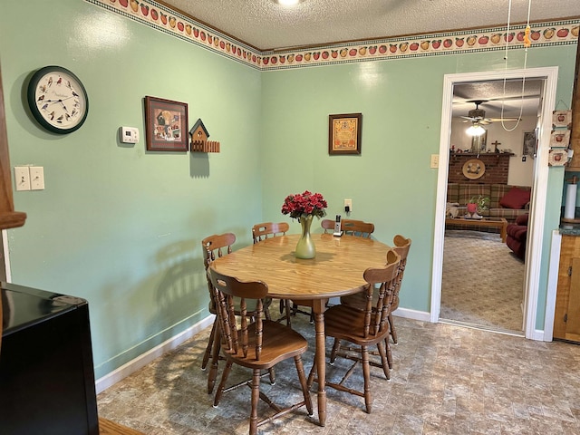 dining room featuring a textured ceiling and baseboards