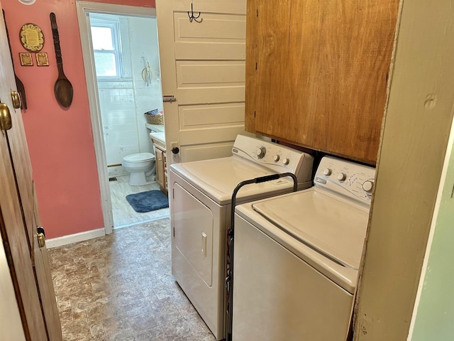 laundry room featuring laundry area, washing machine and clothes dryer, and baseboards