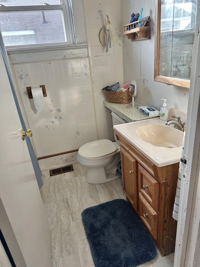 half bath featuring toilet, vanity, and visible vents