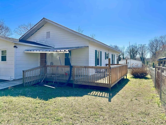 exterior space with a deck, a lawn, and fence