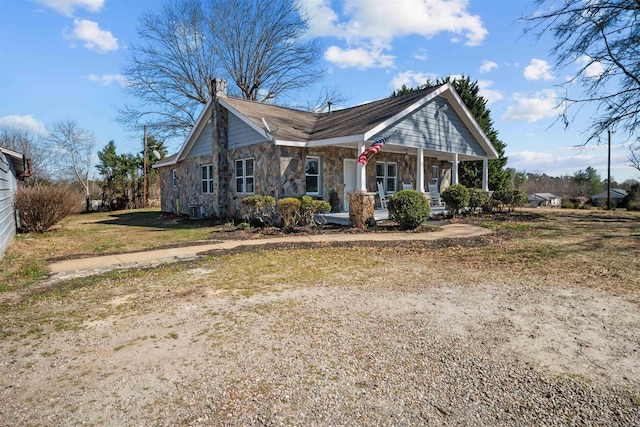 view of front of home featuring covered porch and stone siding