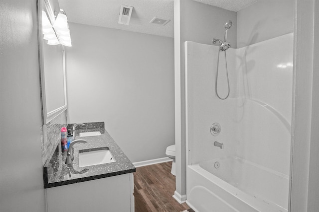 bathroom featuring a textured ceiling, wood finished floors, a sink, and toilet