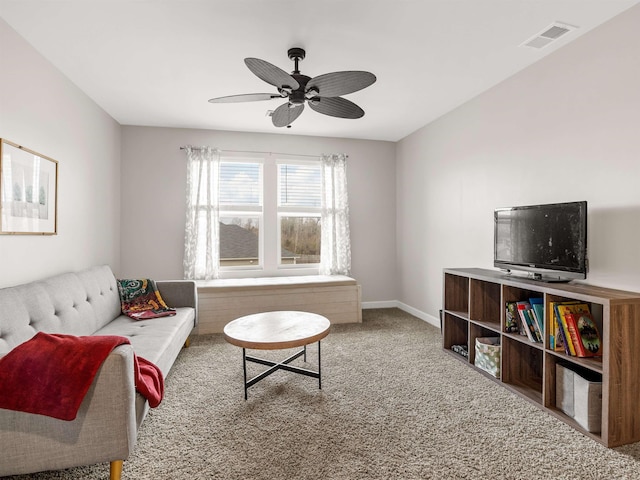 living area with carpet floors, visible vents, baseboards, and a ceiling fan