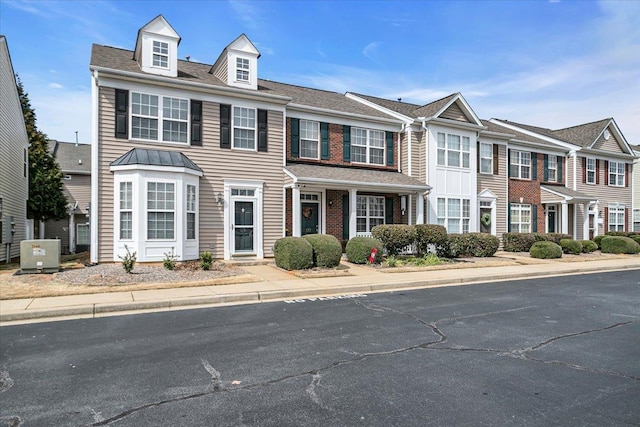 view of property featuring central AC unit and brick siding