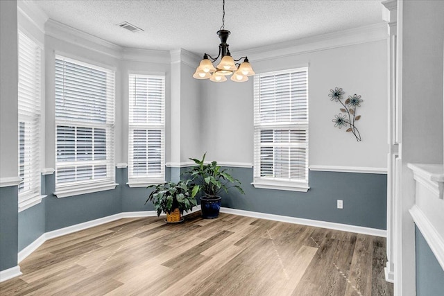 dining room featuring a healthy amount of sunlight, visible vents, and wood finished floors