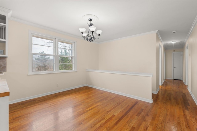 unfurnished dining area featuring crown molding, baseboards, and wood finished floors