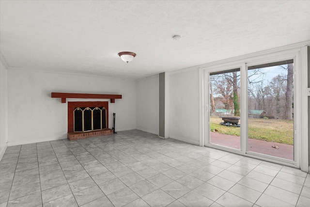 unfurnished living room featuring a textured ceiling, light tile patterned floors, and a brick fireplace