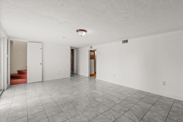 unfurnished room featuring a textured ceiling, stairs, and visible vents