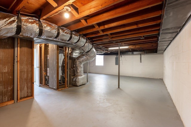 basement featuring electric panel and heating unit