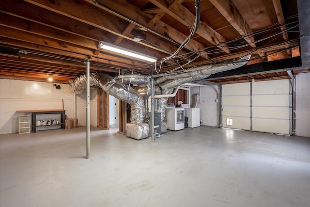 garage featuring independent washer and dryer and heating unit