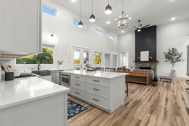 178 Cook, Chesnee, SC 29323 - kitchen featuring a sink, stainless steel dishwasher, light countertops, a stone fireplace, and a kitchen bar