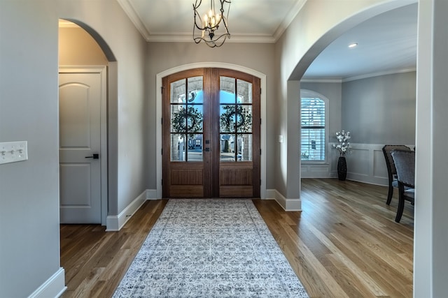 entrance foyer featuring french doors, wood finished floors, and ornamental molding