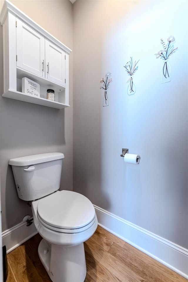 bathroom with wood finished floors, toilet, and baseboards