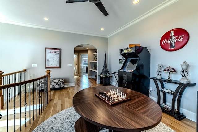 interior space featuring light wood-style flooring, arched walkways, and crown molding