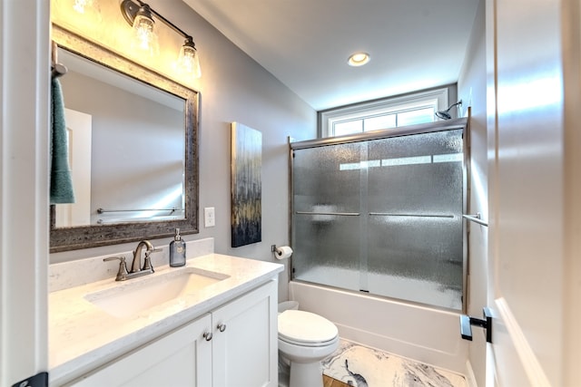 bathroom with shower / bath combination with glass door, vanity, and toilet