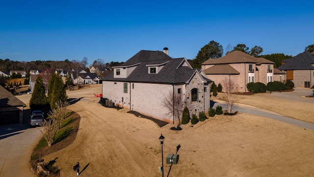 view of property exterior with a residential view and stone siding