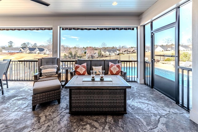 sunroom / solarium featuring plenty of natural light and a residential view