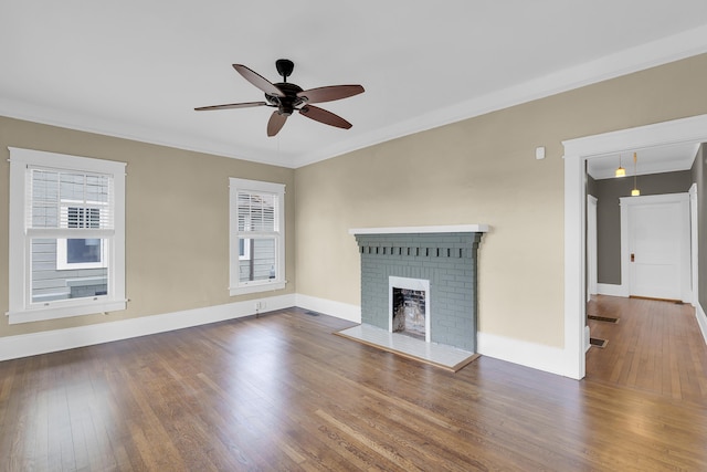 unfurnished living room with crown molding, a fireplace, wood finished floors, and a healthy amount of sunlight