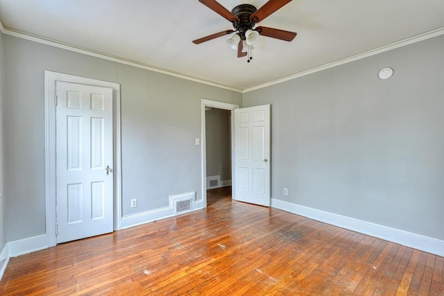 unfurnished bedroom featuring ornamental molding, wood-type flooring, visible vents, and baseboards